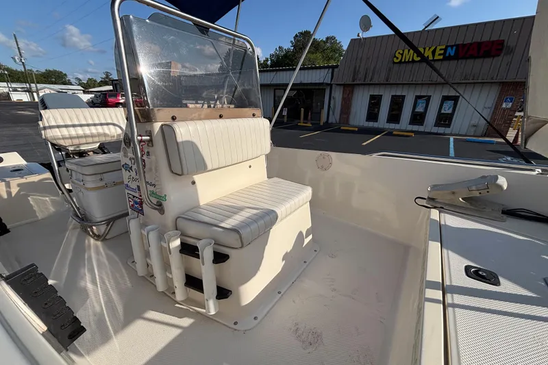 Slide: The Image of 2000 Key West 1720 Center Console boat interior with seating, parked near a store. - 11