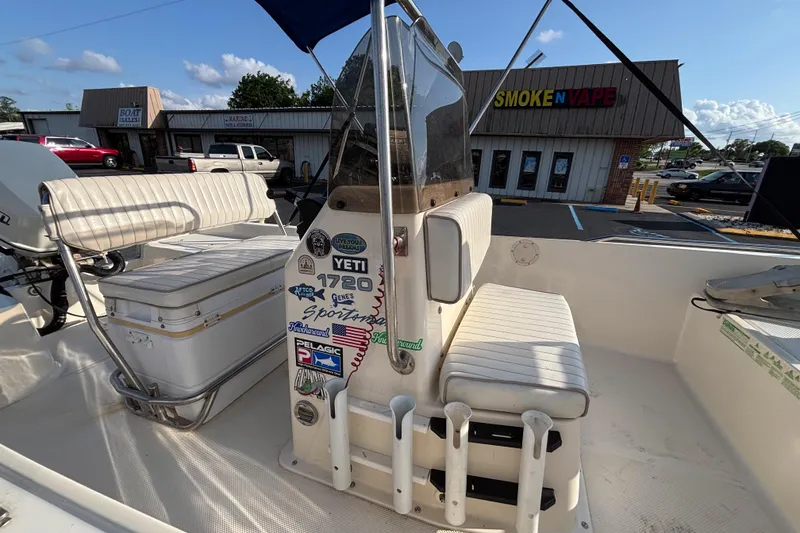 Slide: The Image of Key West 1720 Center Console boat, 2000 model, with stickers and seating, parked near a store. - 13