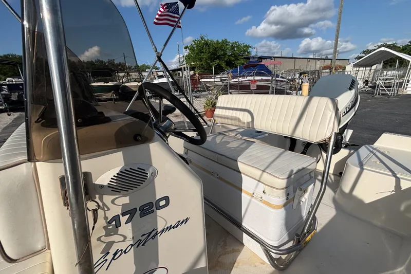 Slide: The Image of 2000 Key West 1720 Center Console boat with seating and steering wheel, outdoors under blue sky. - 23