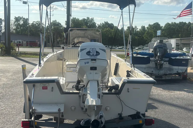 Slide: The Image of 2000 Key West 1720 Center Console boat with 90 HP outboard motor, parked outdoors. - 6