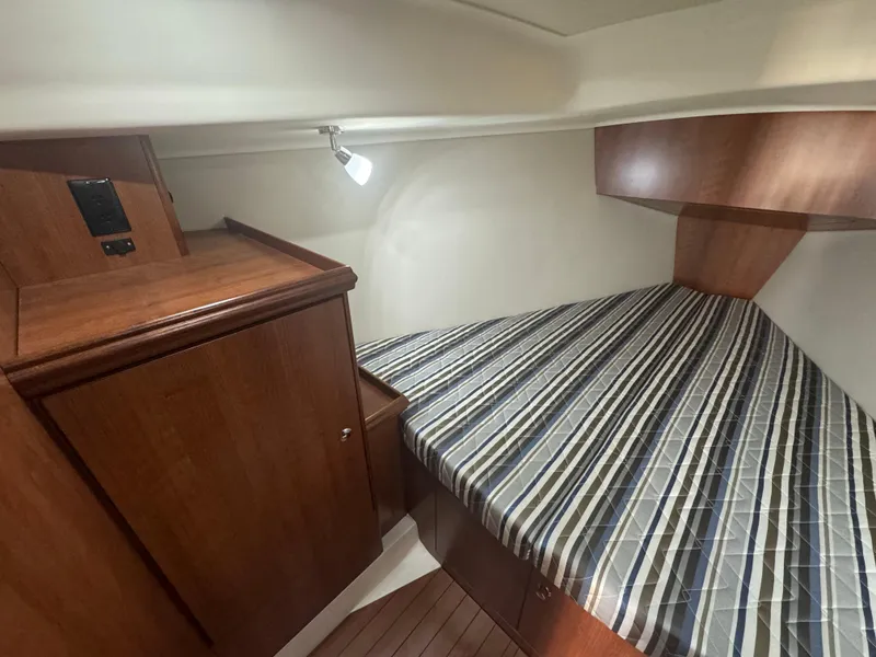Slide: The Image of 2017 Marlow-Hunter 31 cabin interior with striped bedding and wooden cabinetry. - 12
