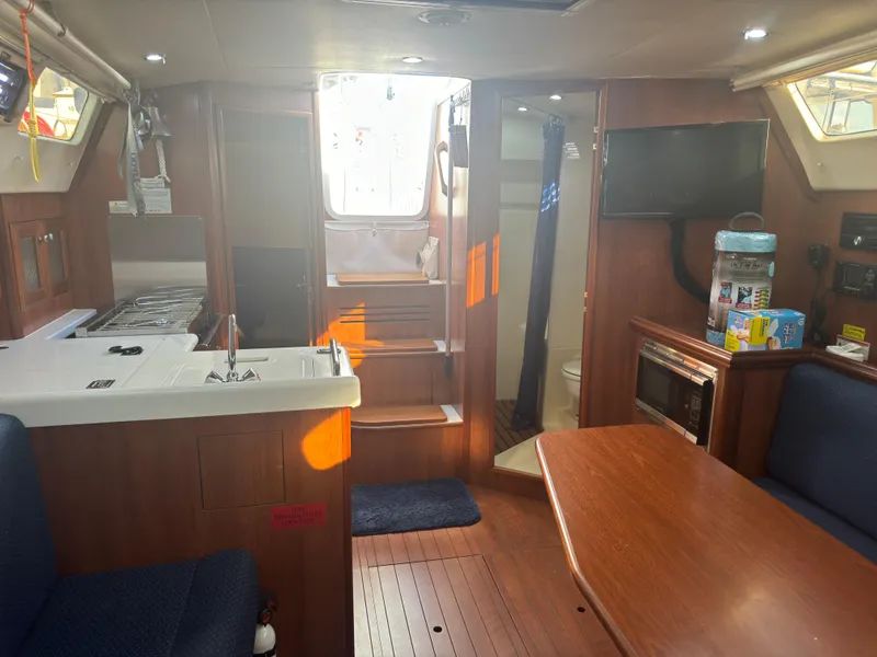 Slide: The Image of Interior of 2017 Marlow-Hunter 31 sailboat with kitchen, dining area, and TV. - 13