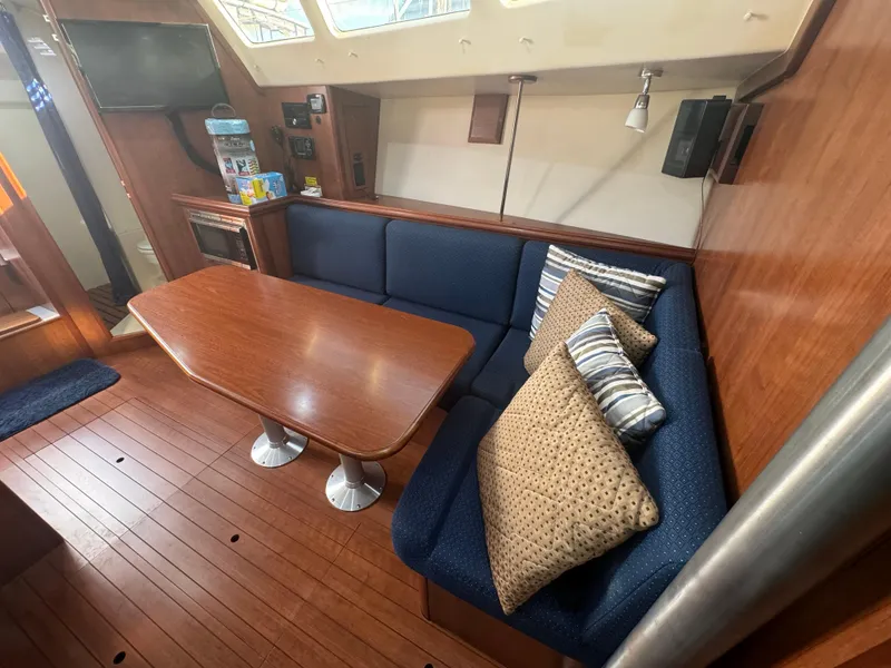 Slide: The Image of Cozy interior of 2017 Marlow-Hunter 31 sailboat with wooden table and blue seating. - 6