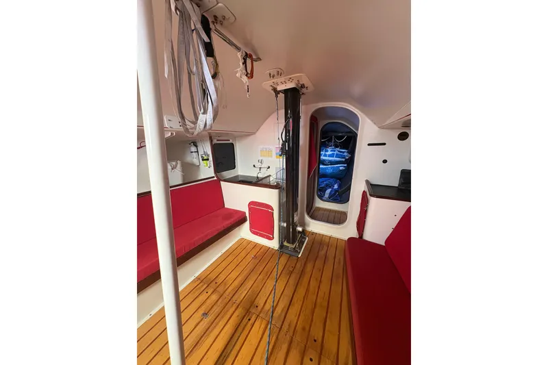 Slide: The Image of Interior of 1999 Laurie Davidson TP-52 yacht with red seating and wooden flooring. - 3