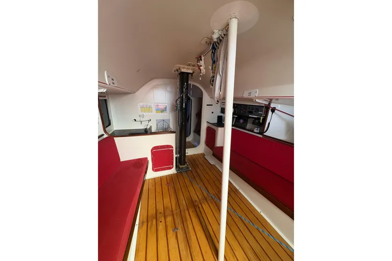 Slide: The Image of Interior of 1999 Laurie Davidson TP-52 yacht with red seating and wooden flooring. - 4