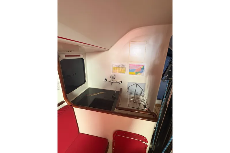 Slide: The Image of Interior of 1999 Laurie Davidson TP-52 yacht with red seating and navigation charts. - 5