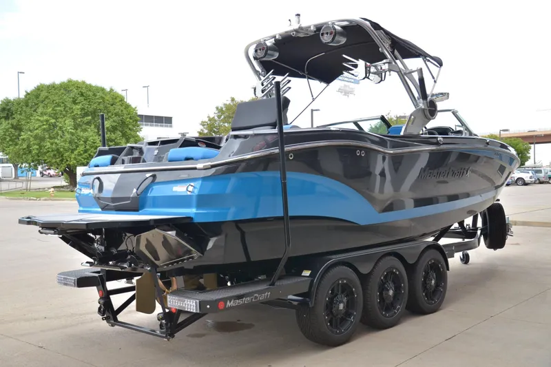 Slide: The Image of 2020 MasterCraft X24 boat on trailer, featuring sleek blue and black design. - 4