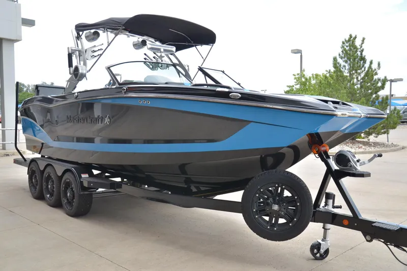 Slide: The Image of 2020 MasterCraft X24 boat on trailer, sleek design with blue and black accents. - 5