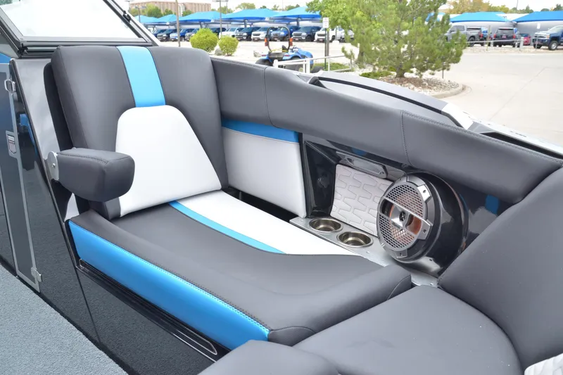 Slide: The Image of 2020 MasterCraft X24 boat interior with blue and white seating, speaker, and cup holders. - 7