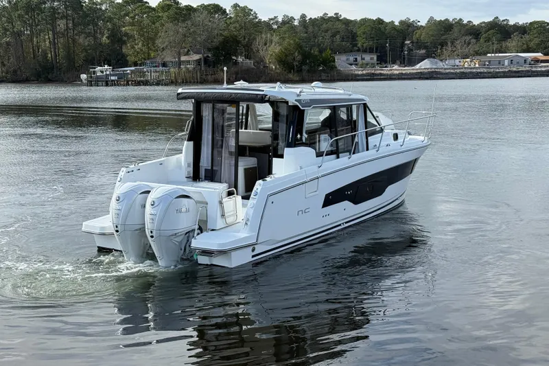 Slide: The Image of 2025 Jeanneau NC 1095 Coupe boat cruising on a calm river. - 4