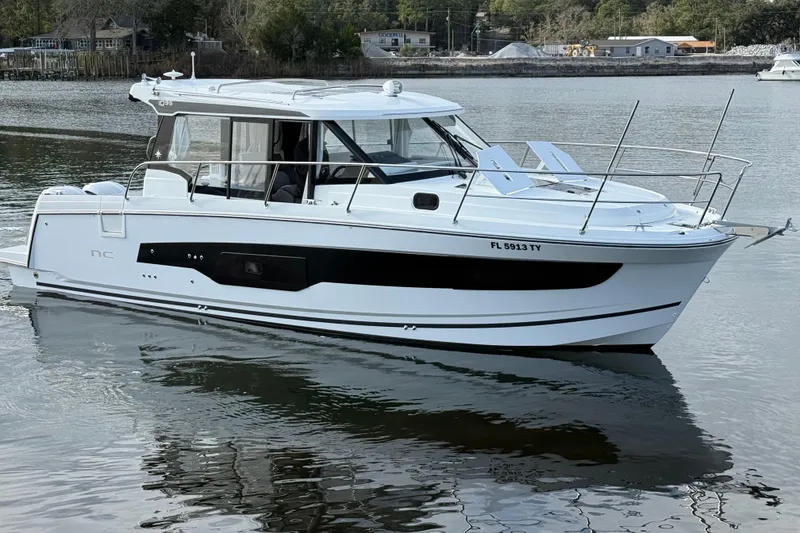 Slide: The Image of 2025 Jeanneau NC 1095 Coupe boat on calm water, side view. - 6