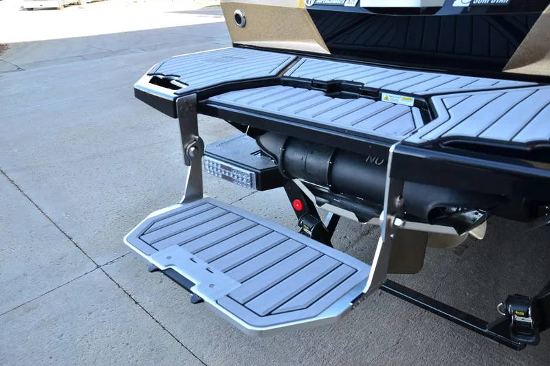 Slide: The Image of 2024 MasterCraft XStar S swim platform with foldable step on concrete surface. - 20