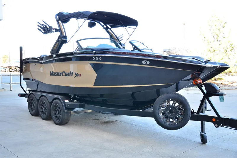 Slide: The Image of 2024 MasterCraft XStar S boat on trailer, sleek design, black and gold accents. - 5