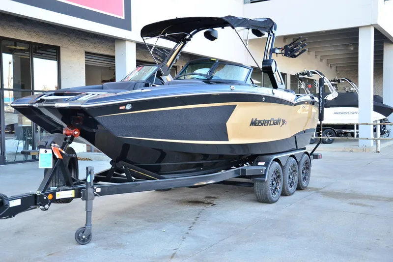 Slide: The Image of 2024 MasterCraft XStar S boat on a trailer, displayed outdoors. - 6