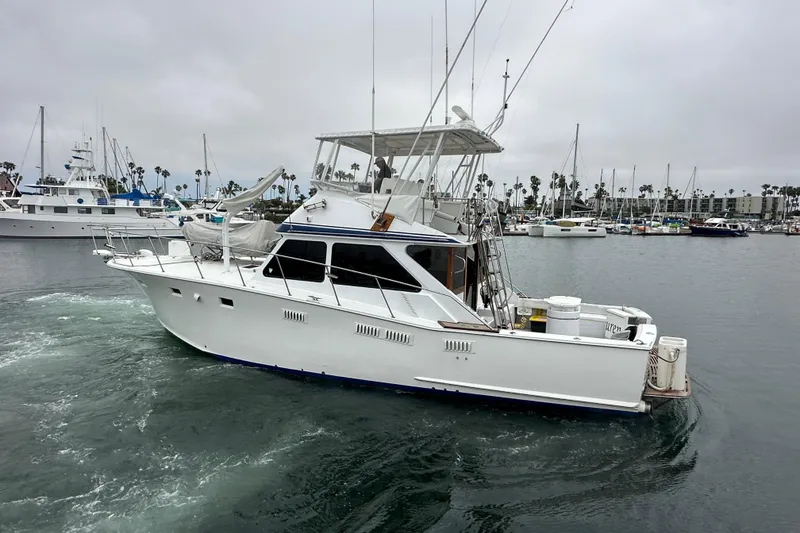 Slide: The Image of 1976 Pacifica Flybridge yacht cruising in a marina with overcast skies. - 1