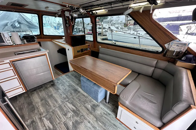 Slide: The Image of Interior of a 1976 Pacifica Flybridge boat with seating and kitchenette. - 16