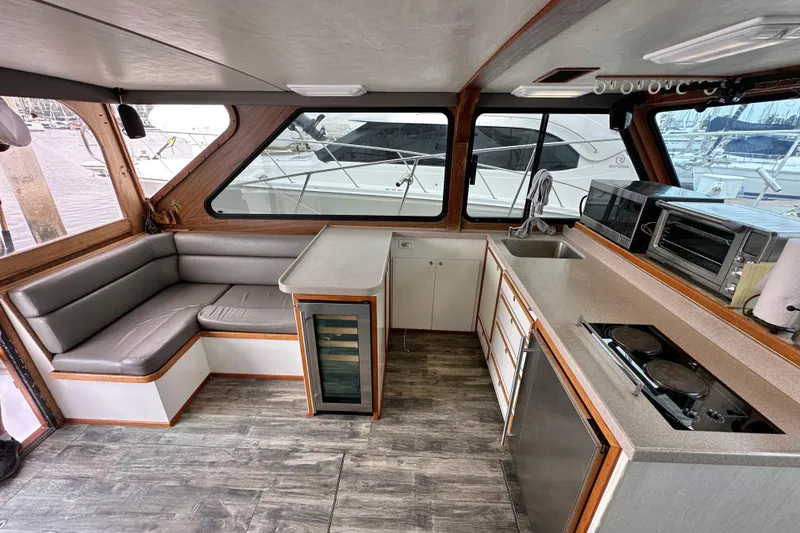 Slide: The Image of Interior of a 1976 Pacifica Flybridge yacht with modern kitchen and seating area. - 17