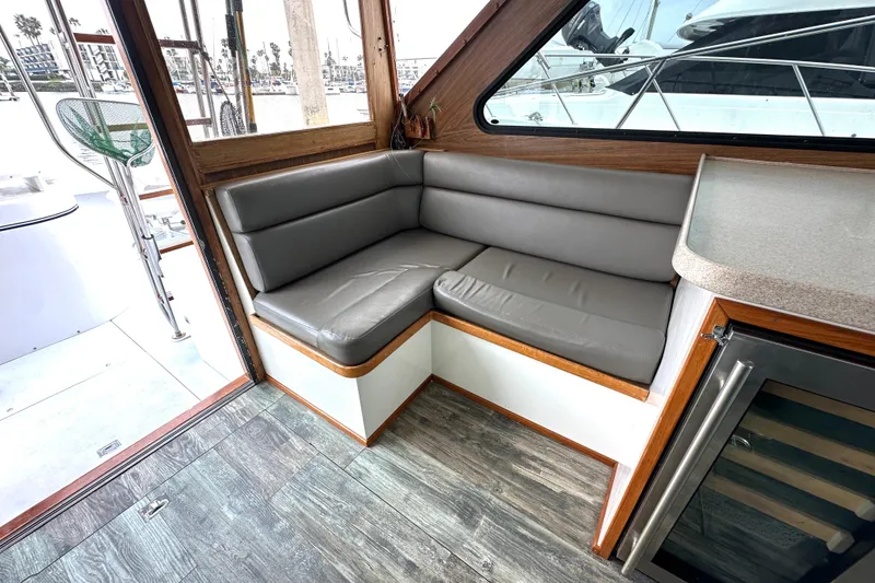 Slide: The Image of 1976 Pacifica Flybridge interior with gray cushioned seating and wood accents. - 18