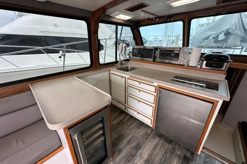 Slide: The Image of 1976 Pacifica Flybridge yacht interior with modern kitchen appliances and sleek countertops. - 19
