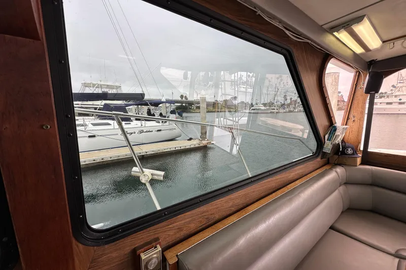 Slide: The Image of Interior view from a 1976 Pacifica Flybridge boat, overlooking a marina through large windows. - 20