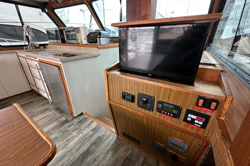 Slide: The Image of 1976 Pacifica Flybridge interior with kitchen, TV, and control panel. - 21