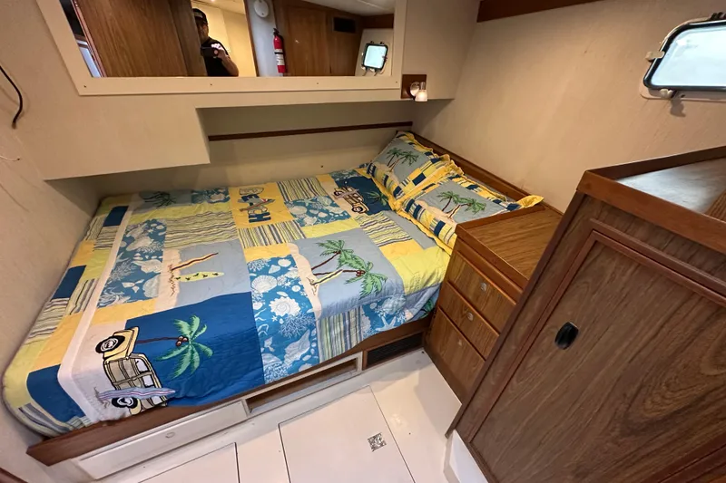 Slide: The Image of Cozy cabin interior of a 1976 Pacifica Flybridge with colorful bedding and wooden furnishings. - 26