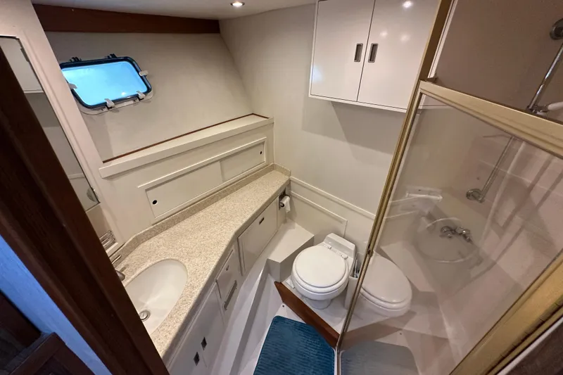 Slide: The Image of 1976 Pacifica Flybridge yacht bathroom with sink, toilet, shower, and storage cabinets. - 27