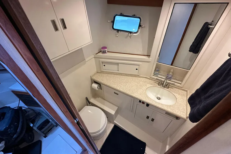 Slide: The Image of 1976 Pacifica Flybridge bathroom with sink, toilet, and storage cabinets. - 29