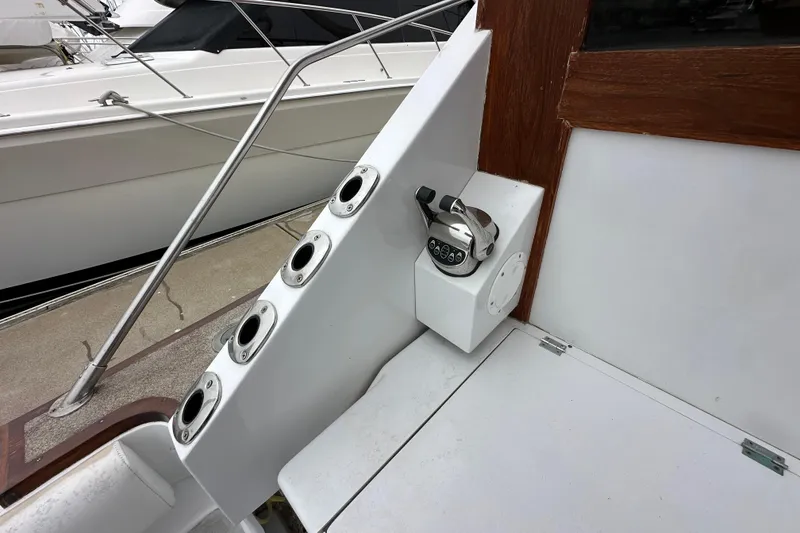 Slide: The Image of 1976 Pacifica Flybridge boat control panel with rod holders and wooden trim. - 32