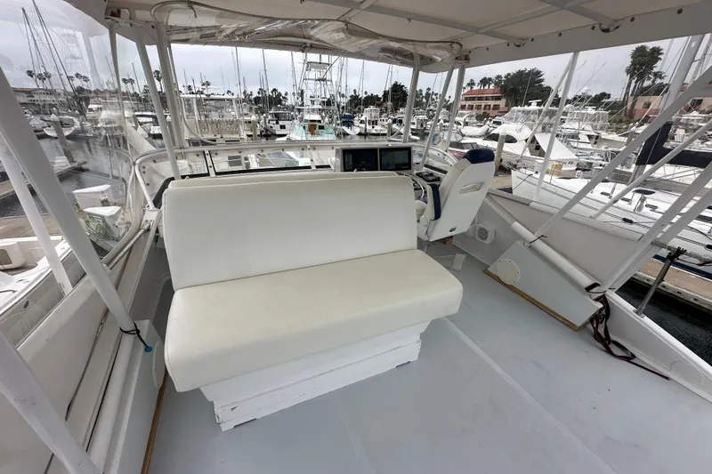 Slide: The Image of 1976 Pacifica Flybridge boat interior with white seating, docked at a marina. - 34