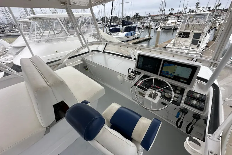 Slide: The Image of 1976 Pacifica Flybridge yacht helm with navigation screens, docked in a marina. - 35