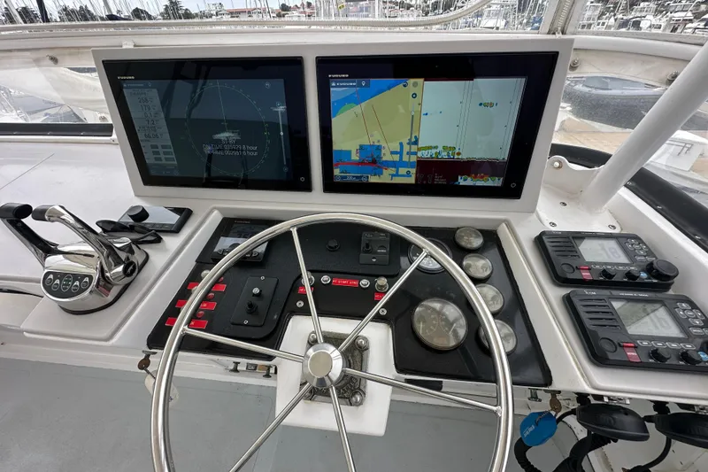 Slide: The Image of 1976 Pacifica Flybridge helm with dual screens, navigation controls, and steering wheel. - 37