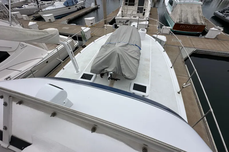 Slide: The Image of 1976 Pacifica Flybridge yacht docked at marina, covered equipment on deck. - 39