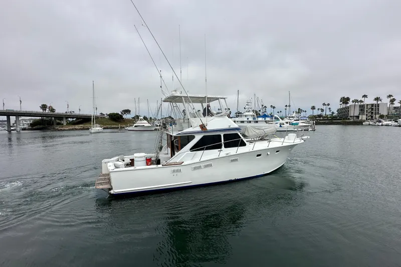 Slide: The Image of 1976 Pacifica Flybridge yacht cruising in a marina with overcast skies. - 4