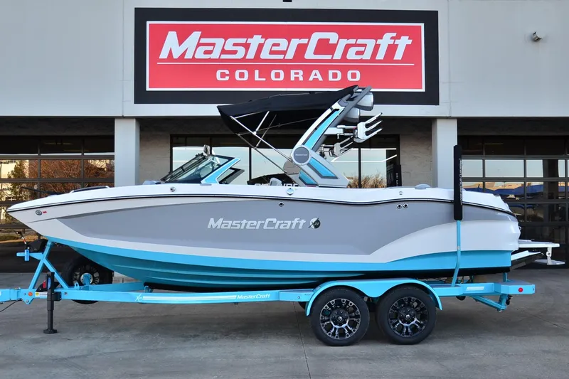Slide: The Image of 2024 MasterCraft X22 boat on trailer at dealership, featuring sleek design and vibrant colors. - 1