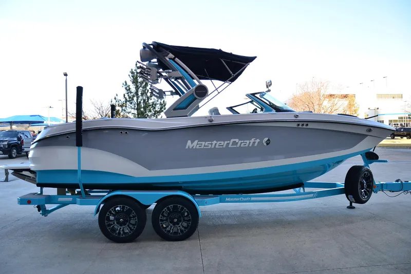 Slide: The Image of 2024 MasterCraft X22 boat on trailer, side view, blue and gray design. - 5
