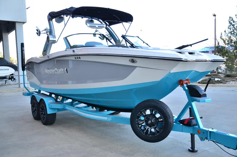 Slide: The Image of 2024 MasterCraft X22 boat on trailer, featuring sleek design and vibrant blue accents. - 6