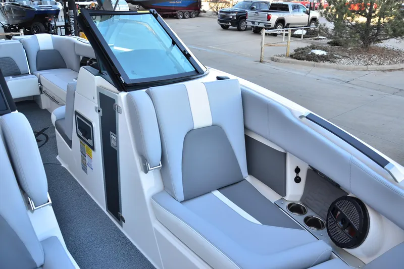 Slide: The Image of 2024 MasterCraft X22 boat interior with gray and white seating, cup holders, and speaker. - 8