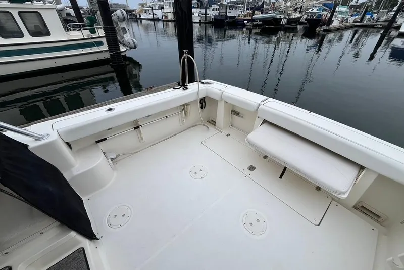 Slide: The Image of 2005 Pursuit 3100 Offshore boat deck at marina, featuring spacious seating and clean design. - 11
