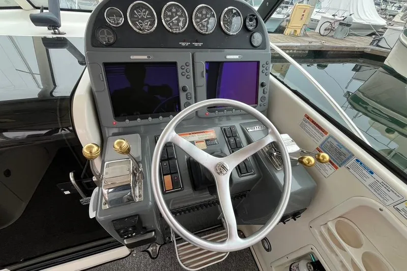 Slide: The Image of 2005 Pursuit 3100 Offshore boat helm with dual screens and steering wheel. - 14
