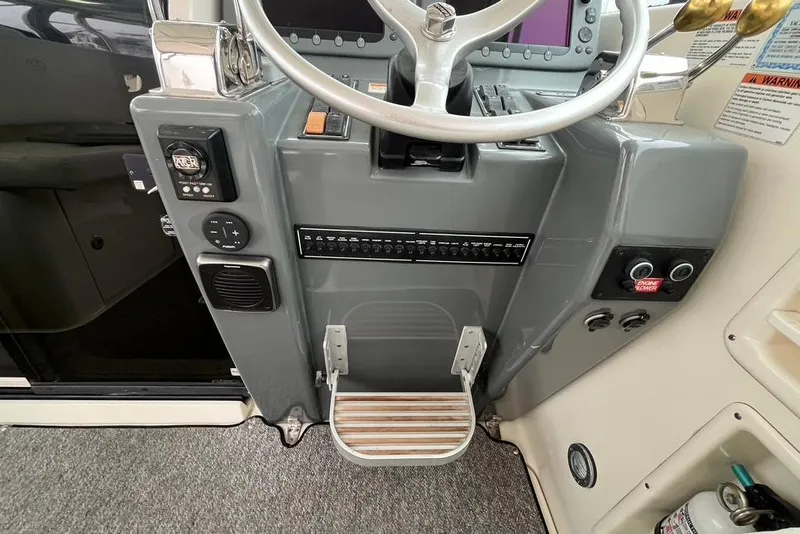 Slide: The Image of 2005 Pursuit 3100 Offshore helm with steering wheel, controls, and footrest. - 15