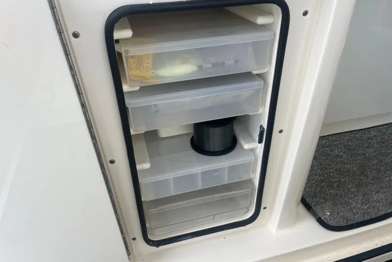 Slide: The Image of Storage compartment with fishing gear on a 2005 Pursuit 3100 Offshore boat. - 19