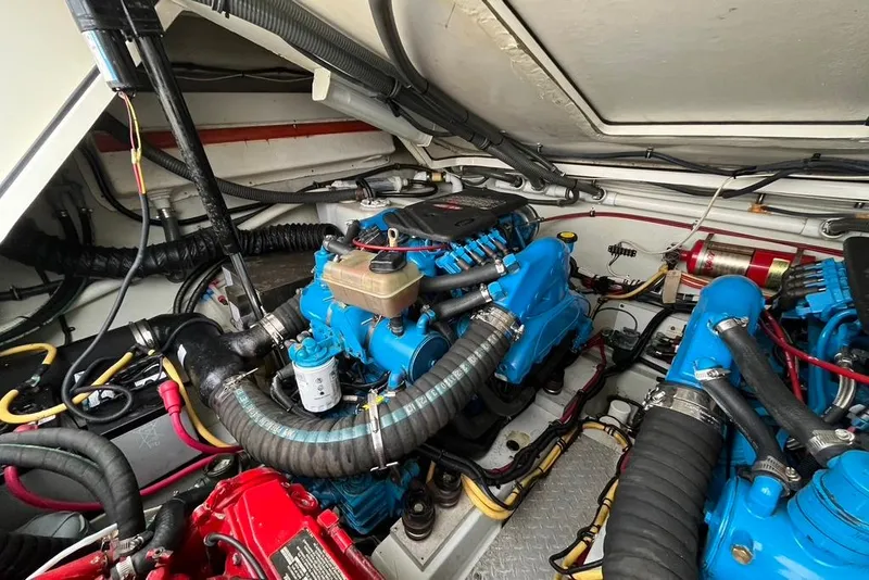 Slide: The Image of Engine room of a 2005 Pursuit 3100 Offshore boat with blue engines and wiring. - 22