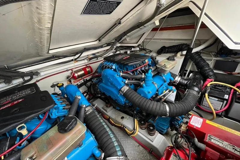 Slide: The Image of Engine compartment of a 2005 Pursuit 3100 Offshore boat, showcasing dual blue engines. - 23