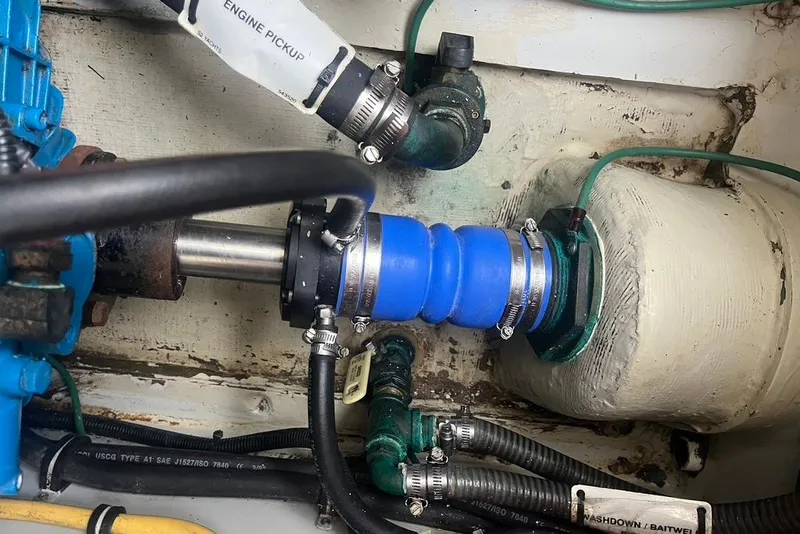 Slide: The Image of Engine compartment of a 2005 Pursuit 3100 Offshore boat, showing hoses and fittings. - 26