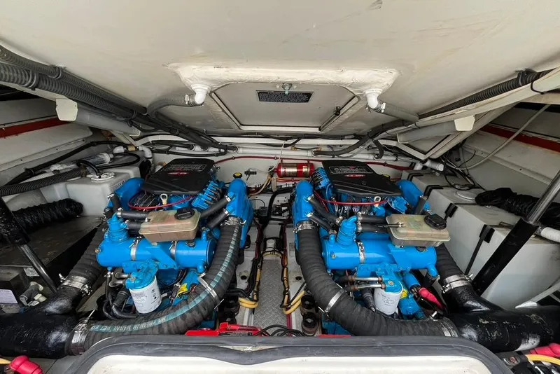 Slide: The Image of Engine compartment of a 2005 Pursuit 3100 Offshore boat, featuring dual blue engines. - 27