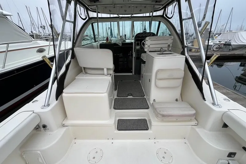 Slide: The Image of 2005 Pursuit 3100 Offshore boat interior with seating and helm, docked at marina. - 29
