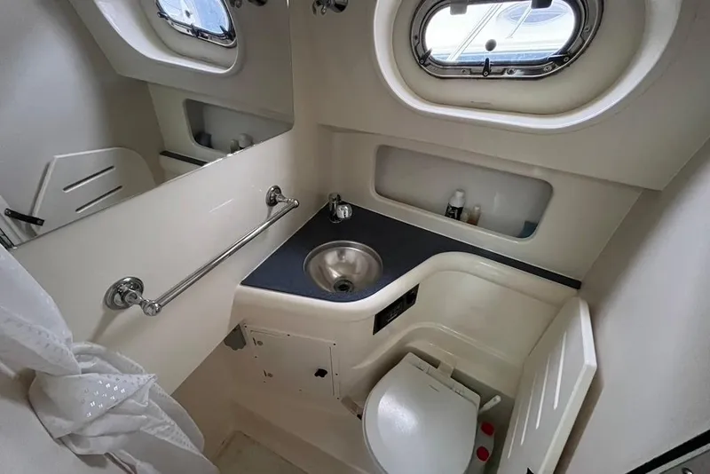 Slide: The Image of Compact bathroom in 2005 Pursuit 3100 Offshore boat with sink and toilet. - 35