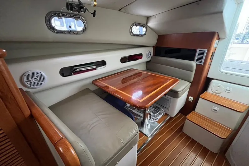 Slide: The Image of Interior of a 2005 Pursuit 3100 Offshore boat with a cozy dining area. - 36