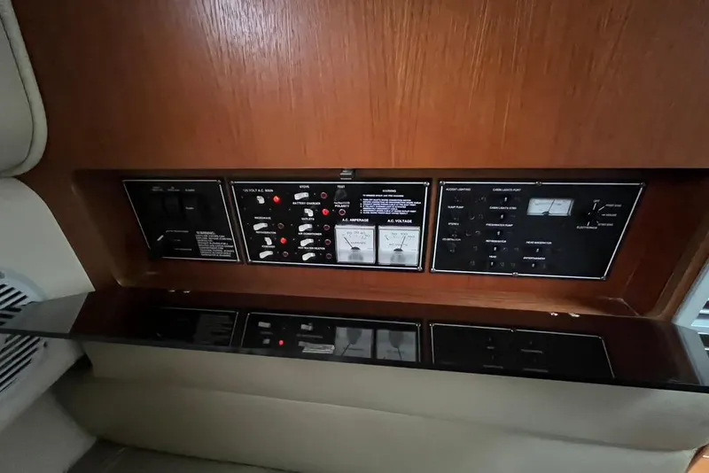 Slide: The Image of Control panel of a 2005 Pursuit 3100 Offshore boat, featuring various switches and gauges. - 38